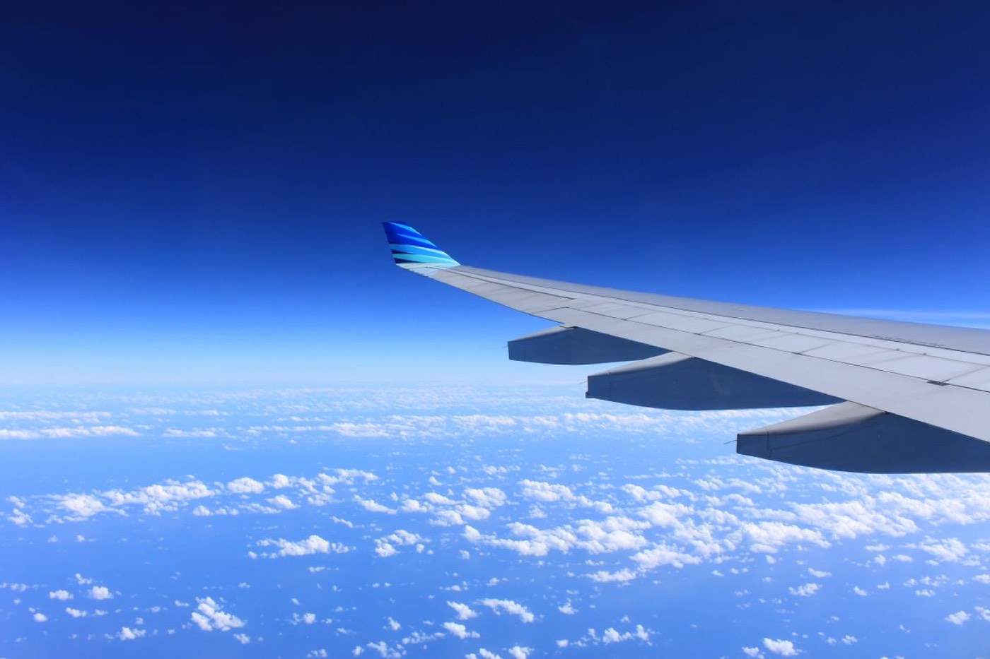 Airplane wing over ocean