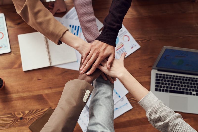Professional office environment with diverse team working at high-end workstations in a minimalist tech office